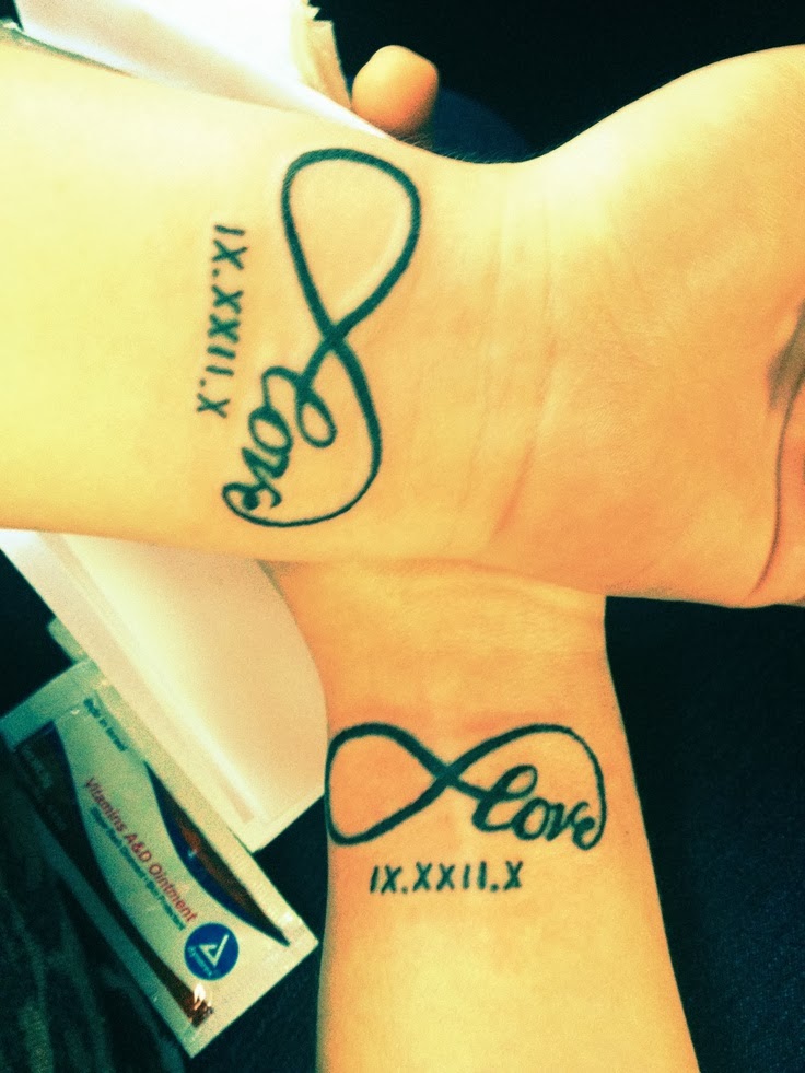 Couple tattoo, love infinity with the date in Roman numerals on wrist