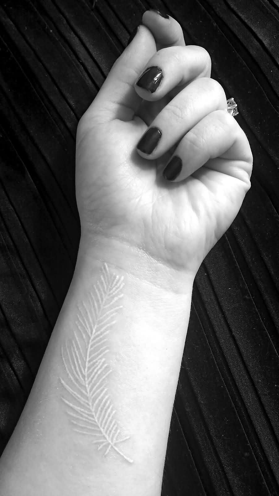white-ink-feather-tattoo-on-wrist