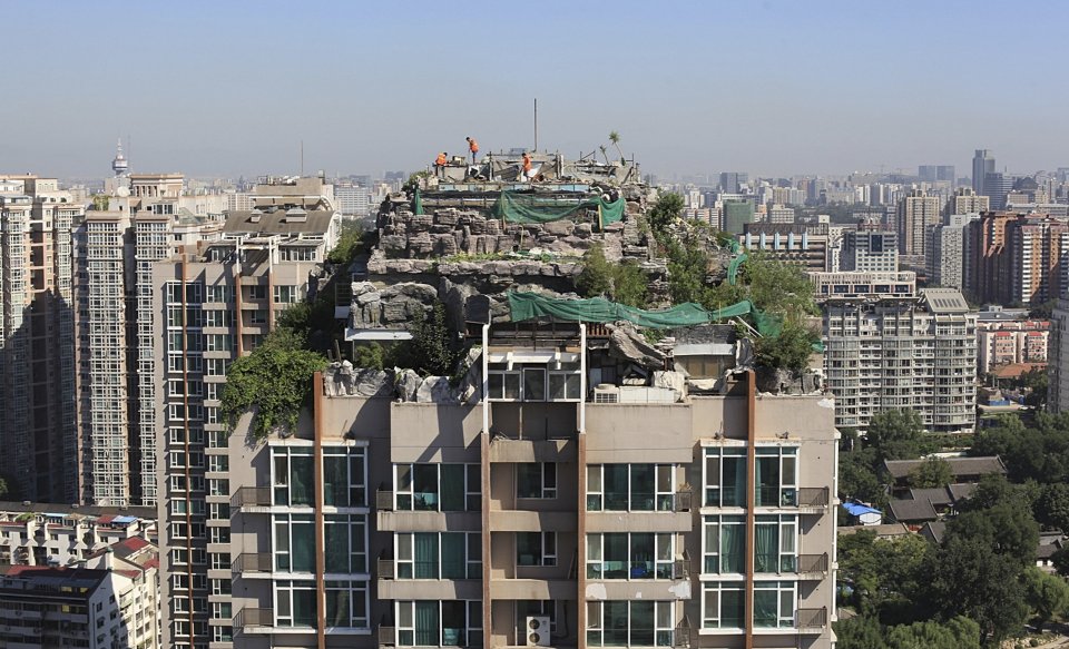 seen-here-workers-demolish-a-privately-built-villa-surrounded-by-imitation-rocks-on-the-rooftop-of-a-26-story-residential-building-in-beijing