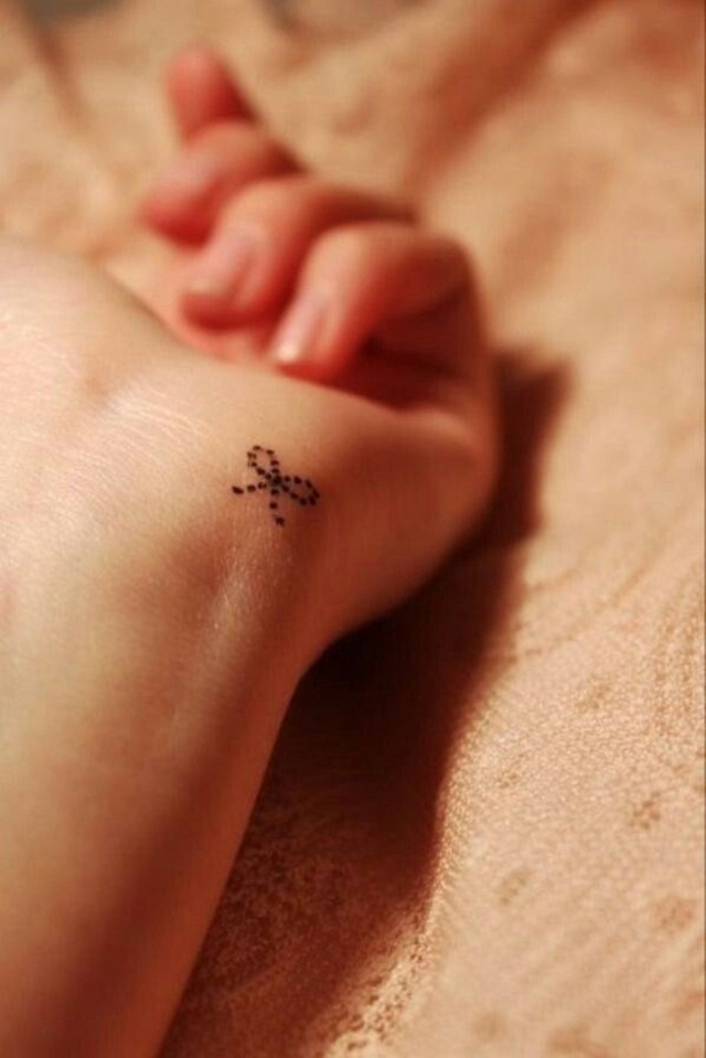 small ribbon tattoo design on wrist for girl