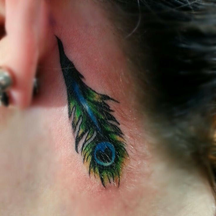Peacock feather behind the ear tattoo