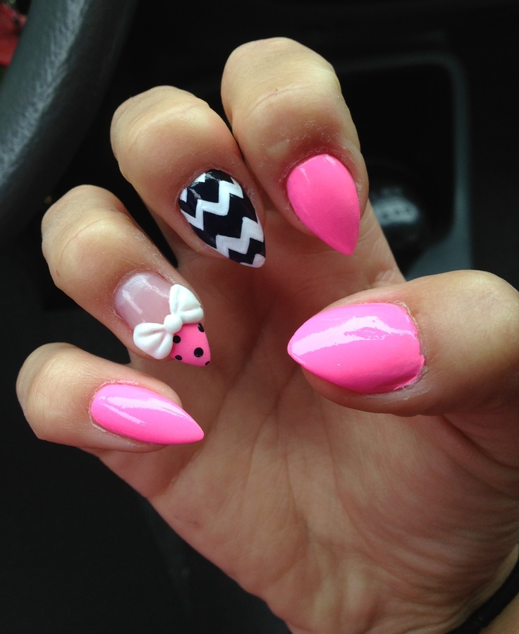 Short pink stiletto nails with a 3D acrylic bow and jem cluster