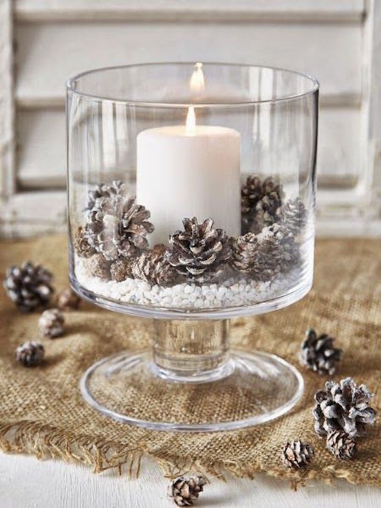 hurricane bowl with white pillar candles and frosted pine cones with white stone chips